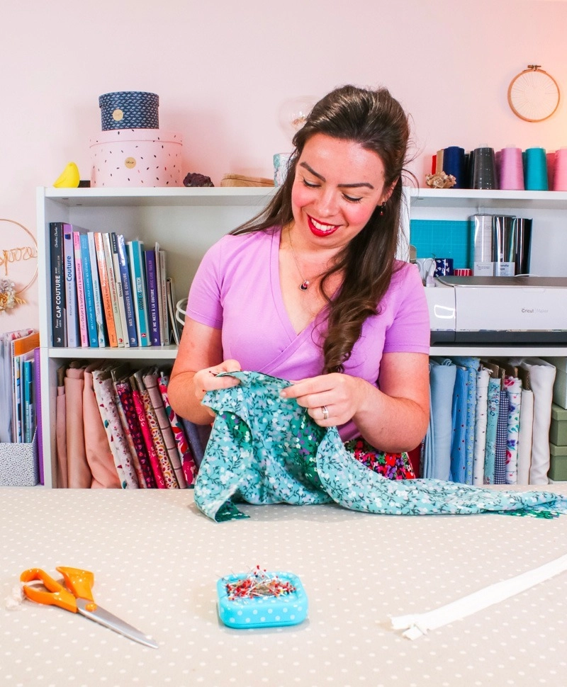 Louise épingle du tissu dans son atelier couture pour coudre une robe